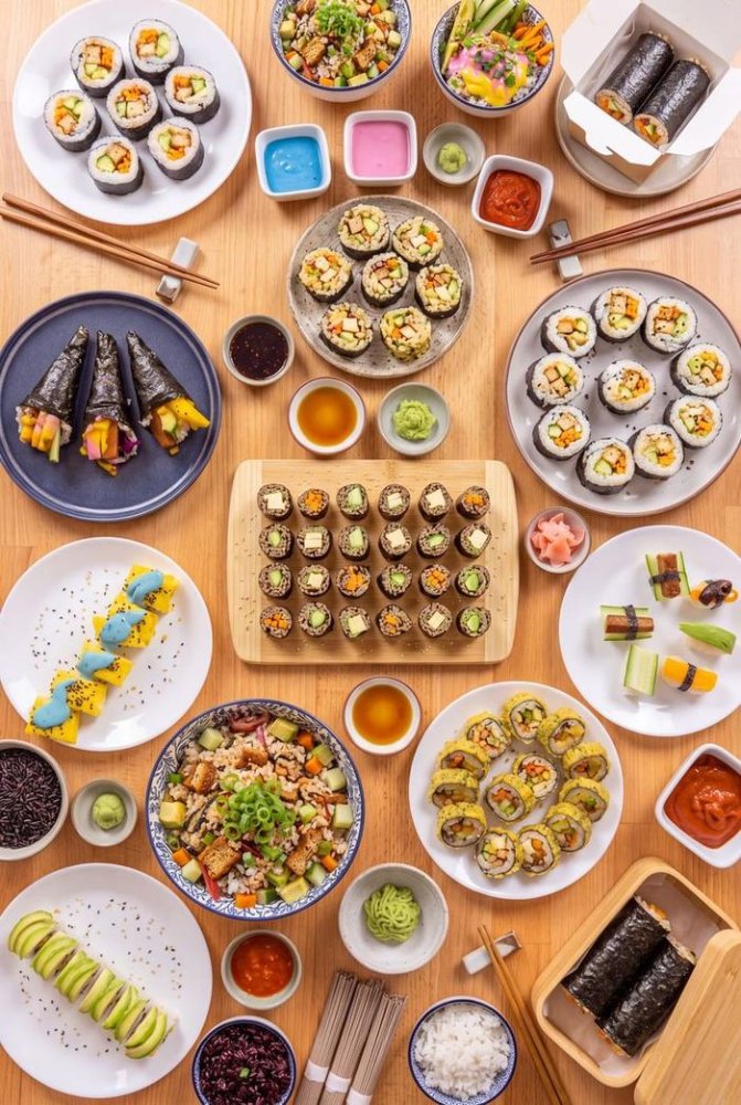 Prostřený stůl plný sushi, omáček a příloh, fotografie ze zadní obálky knihy